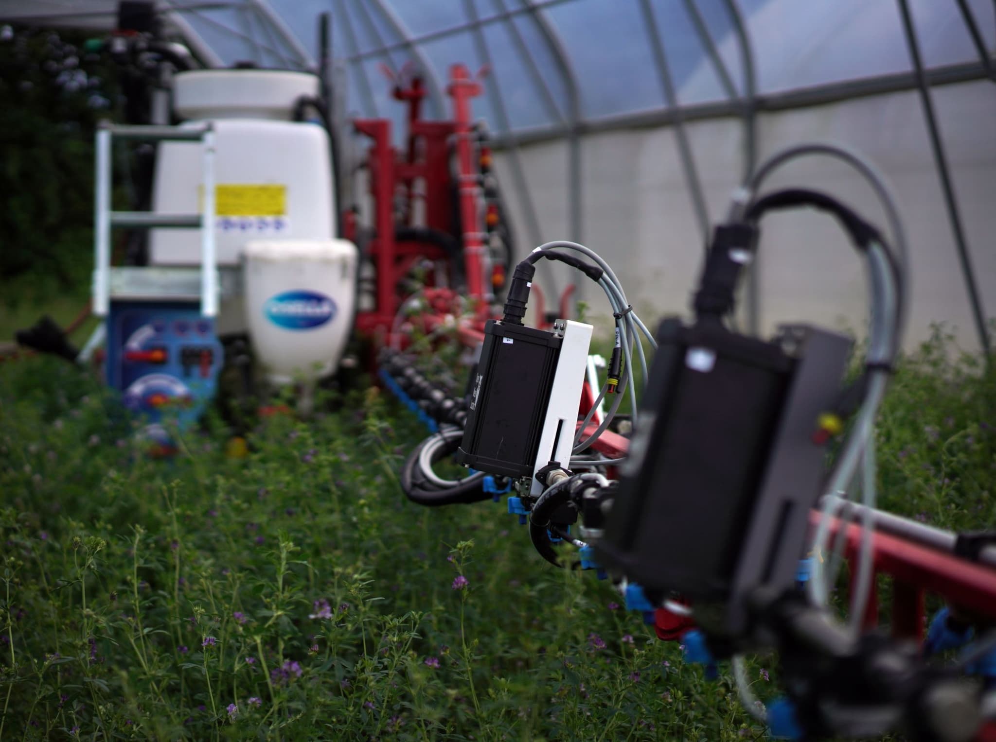 OpenWeedLocator camera units mounted on a spray boom in a field